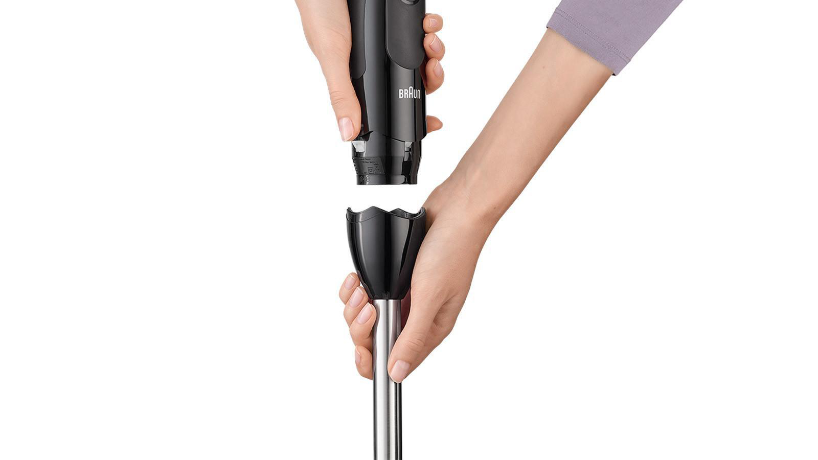 Hände halten einen schwarzen Braun Stabmixer, getrennt zur Verwendung. Weißer Hintergrund.