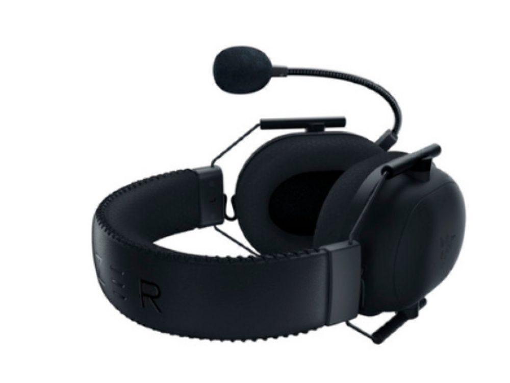 Un auricular para juegos negro con micrófono. Se encuentra sobre un fondo blanco.