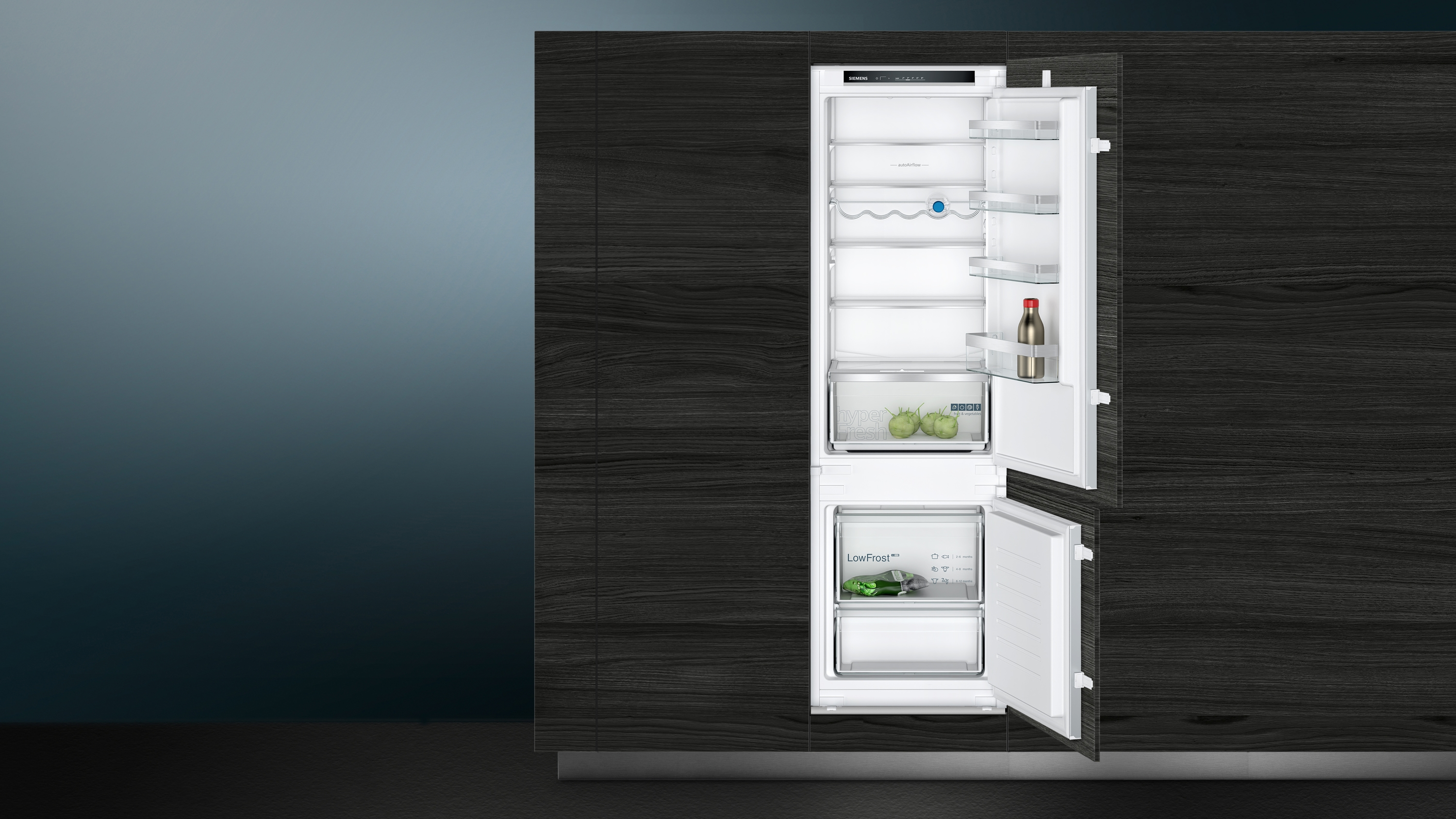Offener Kühlschrank mit Regalen und Schubladen. Schwarze Arbeitsplatte und grauer Hintergrund.