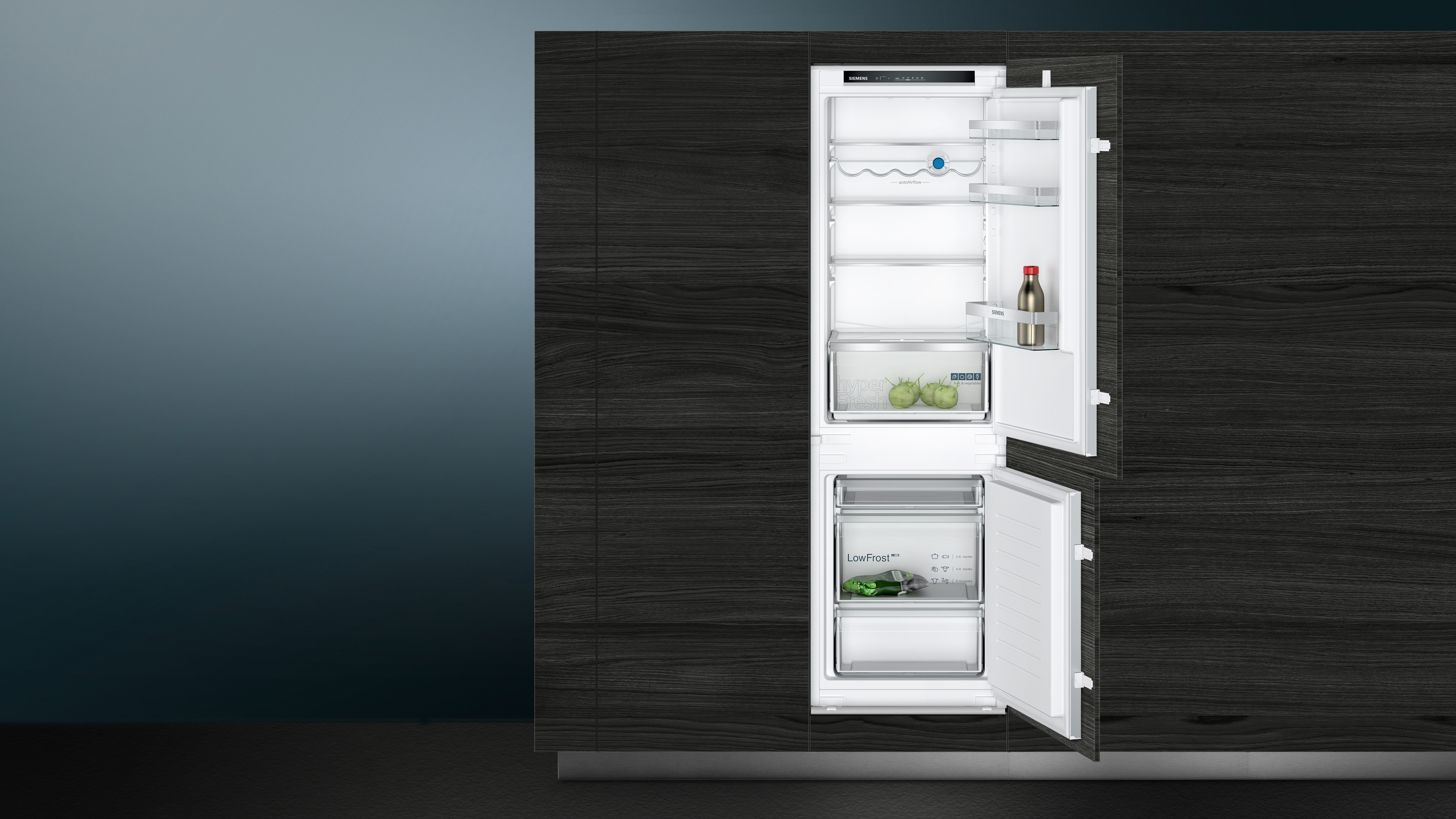 Ein Kühlschrank hat offene Türen und zeigt Innenregale und Inhalte.