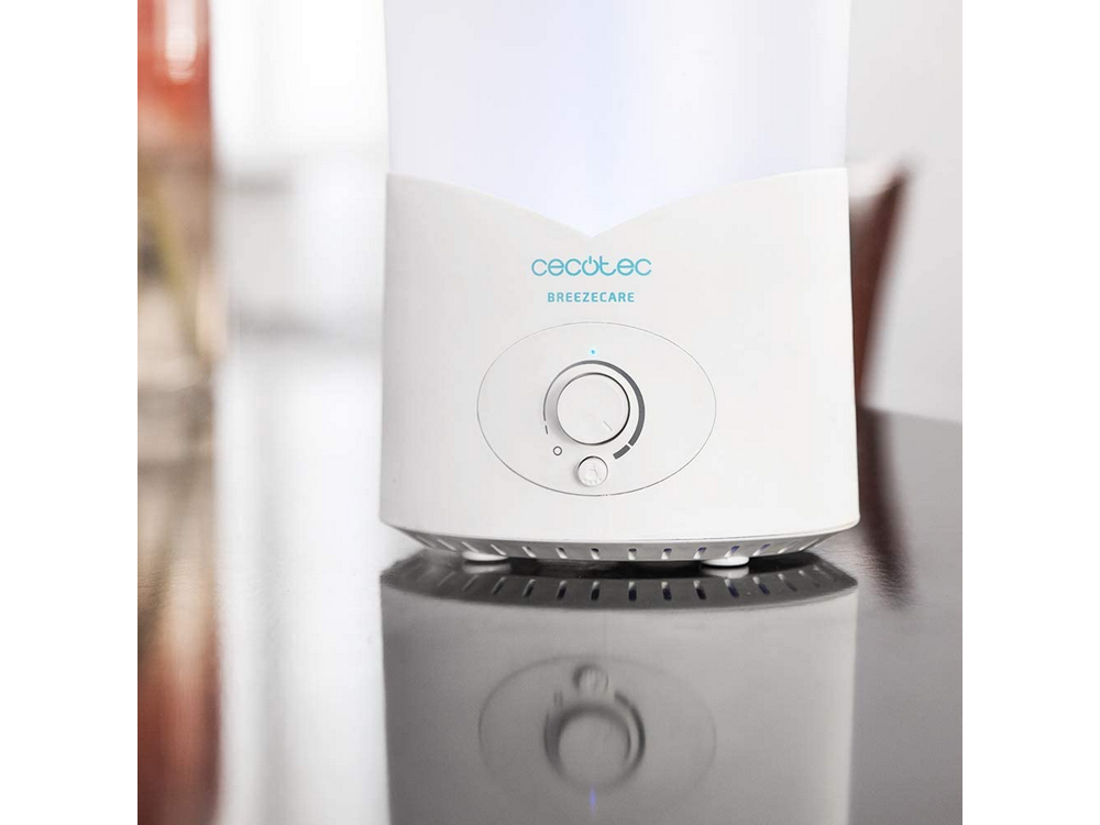 Un humidificador blanco con controles y logo está sobre una mesa.