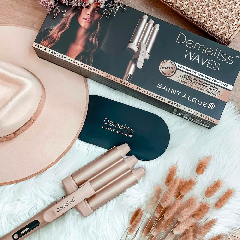 Un ensemble de bigoudis avec un chapeau rose, une boîte et d'autres accessoires sur une surface en fausse fourrure blanche.