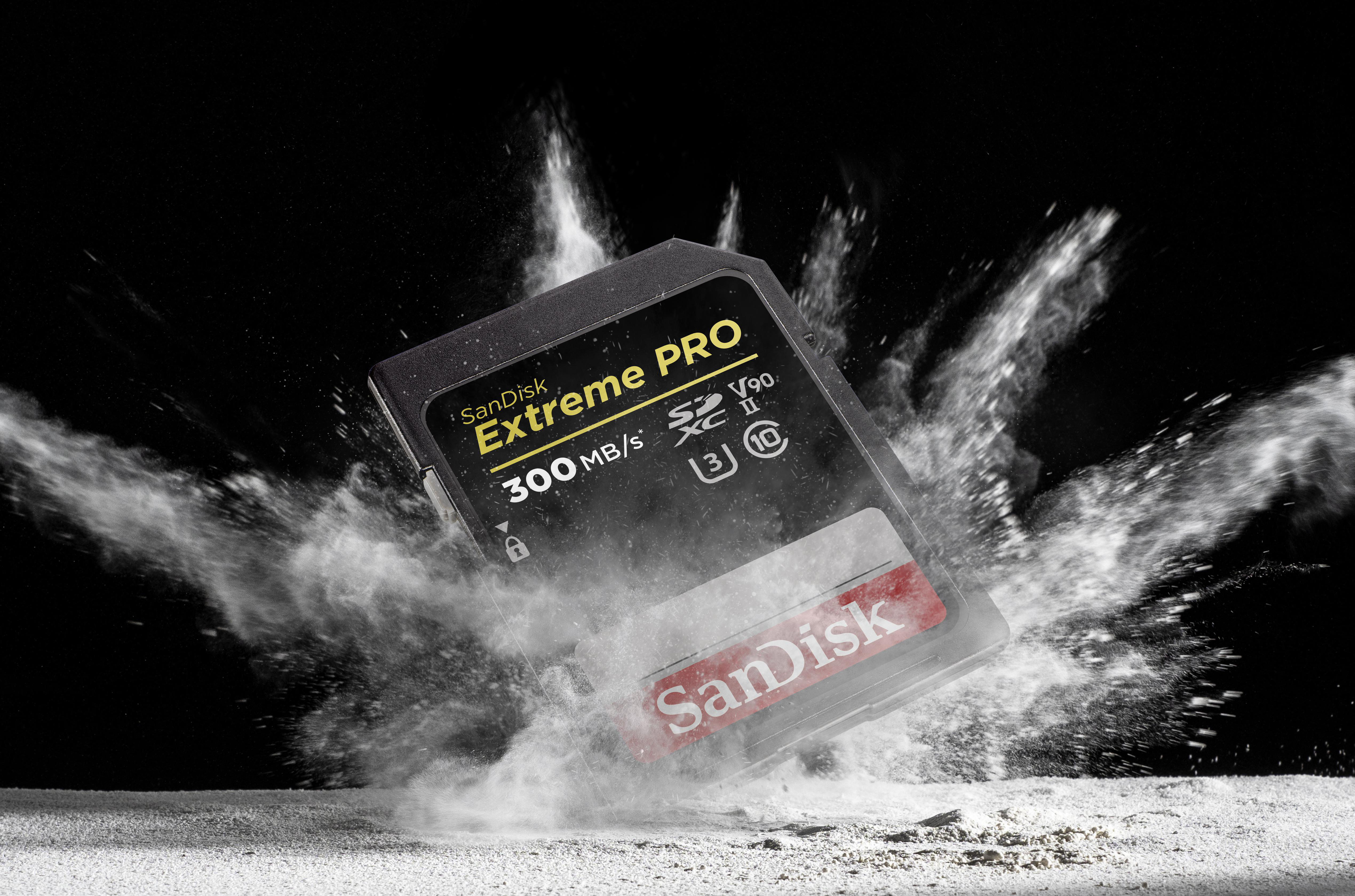SD-Karte, die mit Staub explodiert, vor schwarzem Hintergrund.