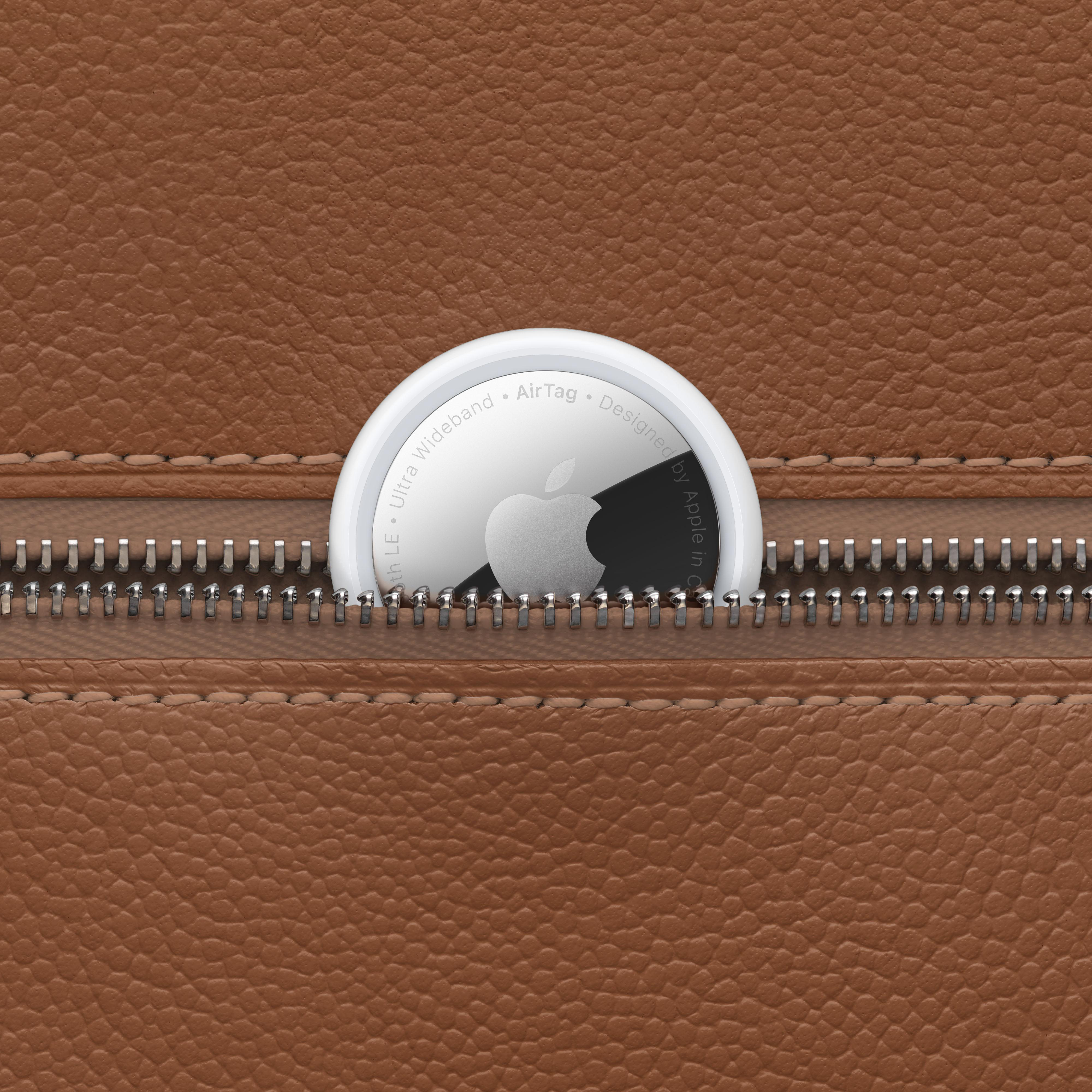 Apple AirTag in einer braunen Ledergeldbörse. Reißverschlussdetail sichtbar.