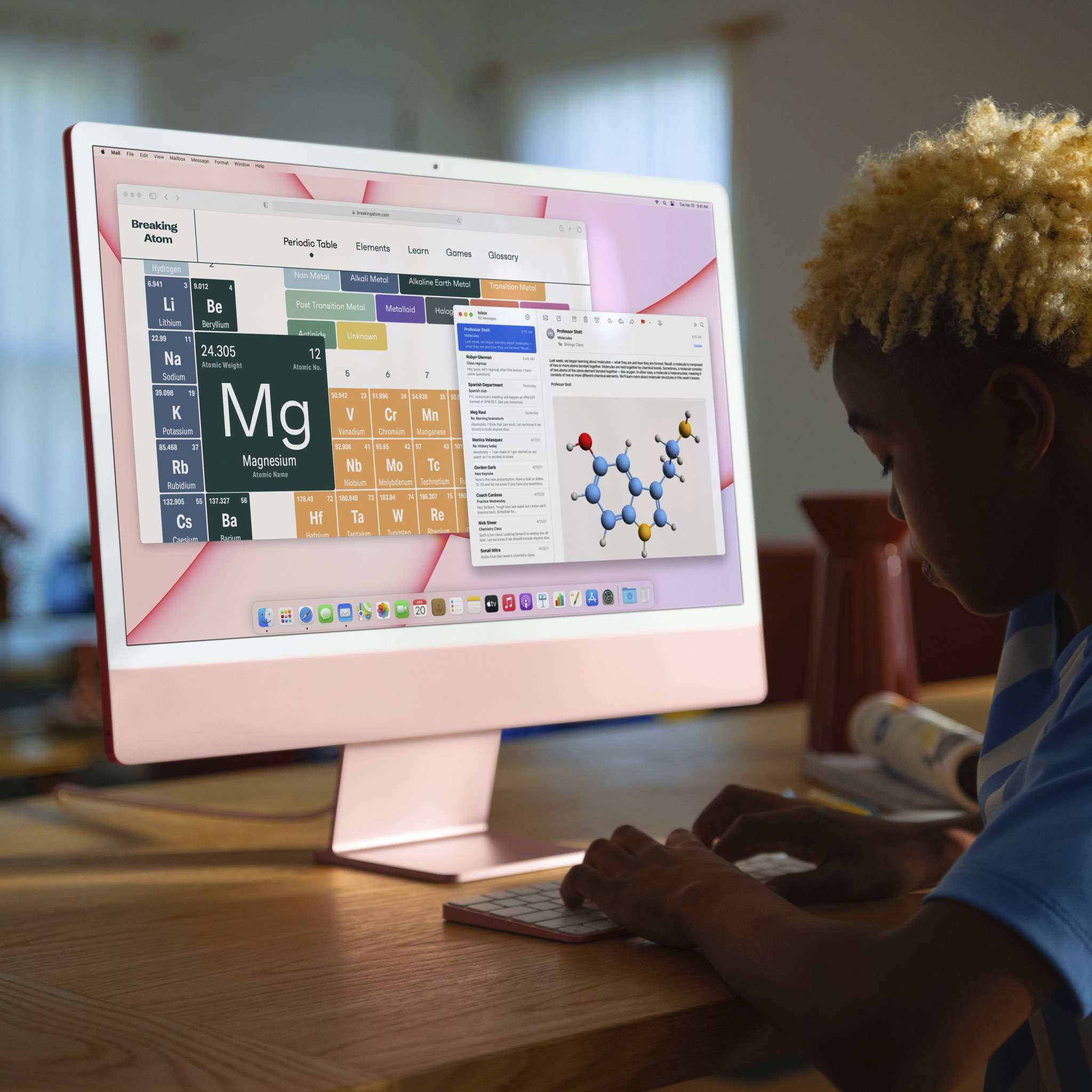 Kind, das einen rosa iMac benutzt, konzentriert sich auf den Bildschirm mit Periodensystem.