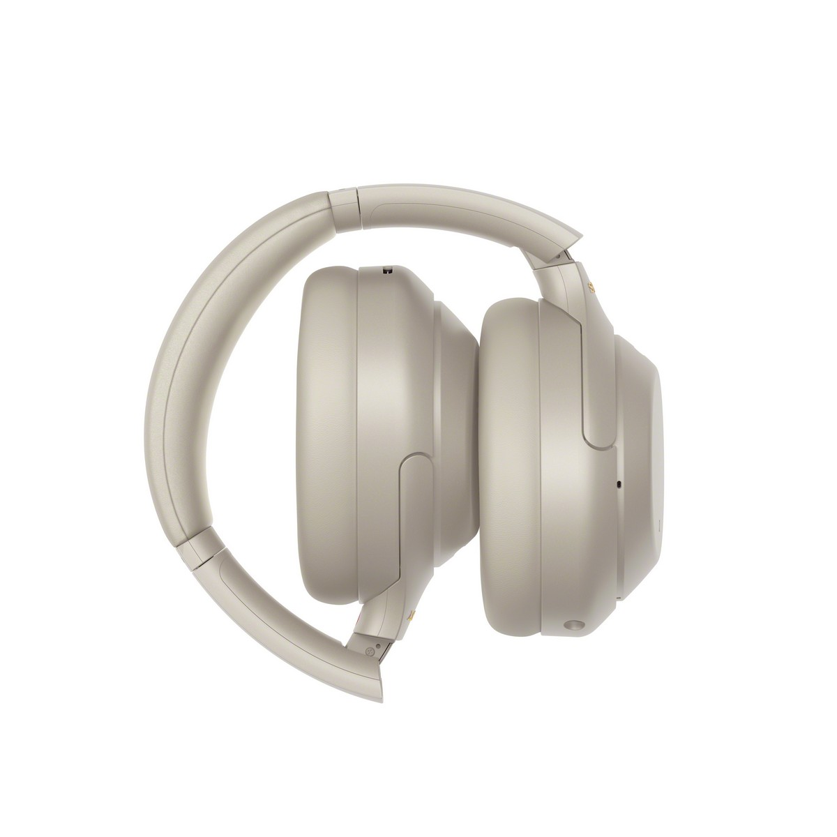 Auriculares beige plegados. El diseño es elegante y moderno, con un acabado suave y mate.