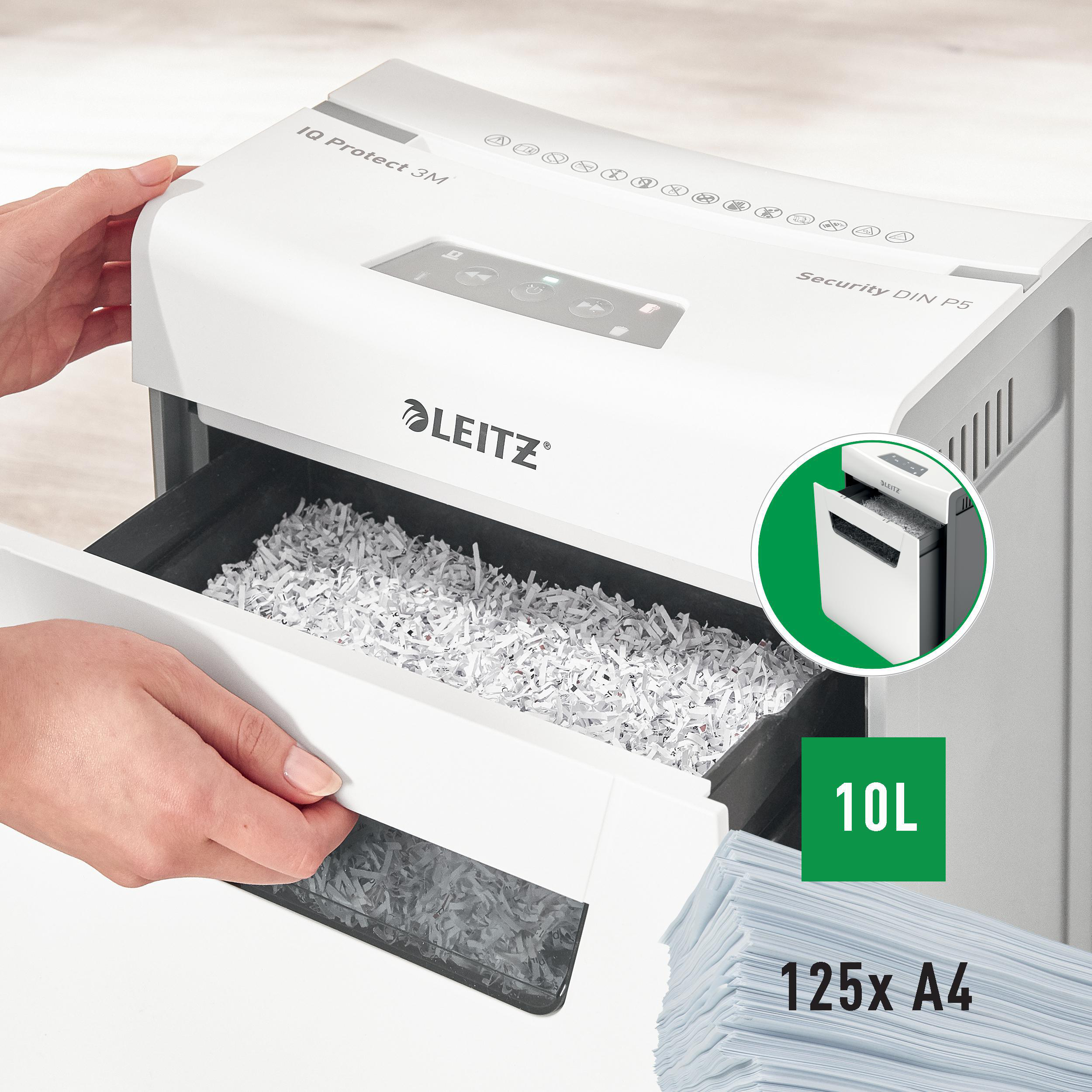 Ein weißer Leitz Aktenvernichter, mit geöffneter Schublade, gefüllt mit geschreddertem Papier. Eine Hand zieht die Schublade.