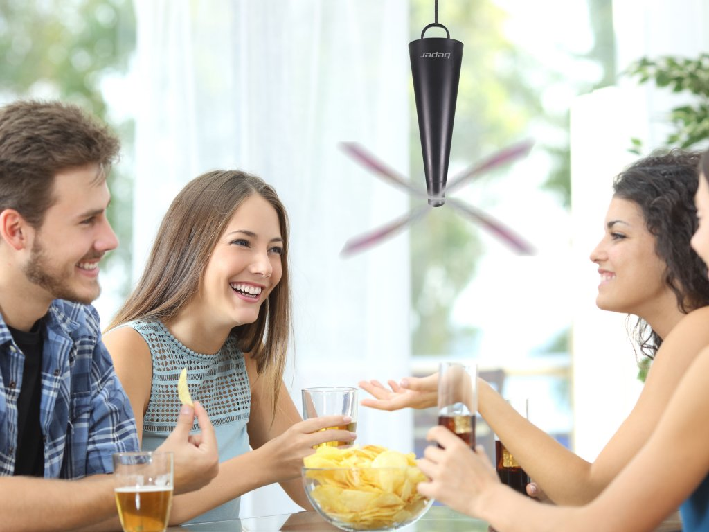 Quatre personnes rient, mangent des chips et boivent. Un ventilateur est suspendu. Intérieur lumineux.