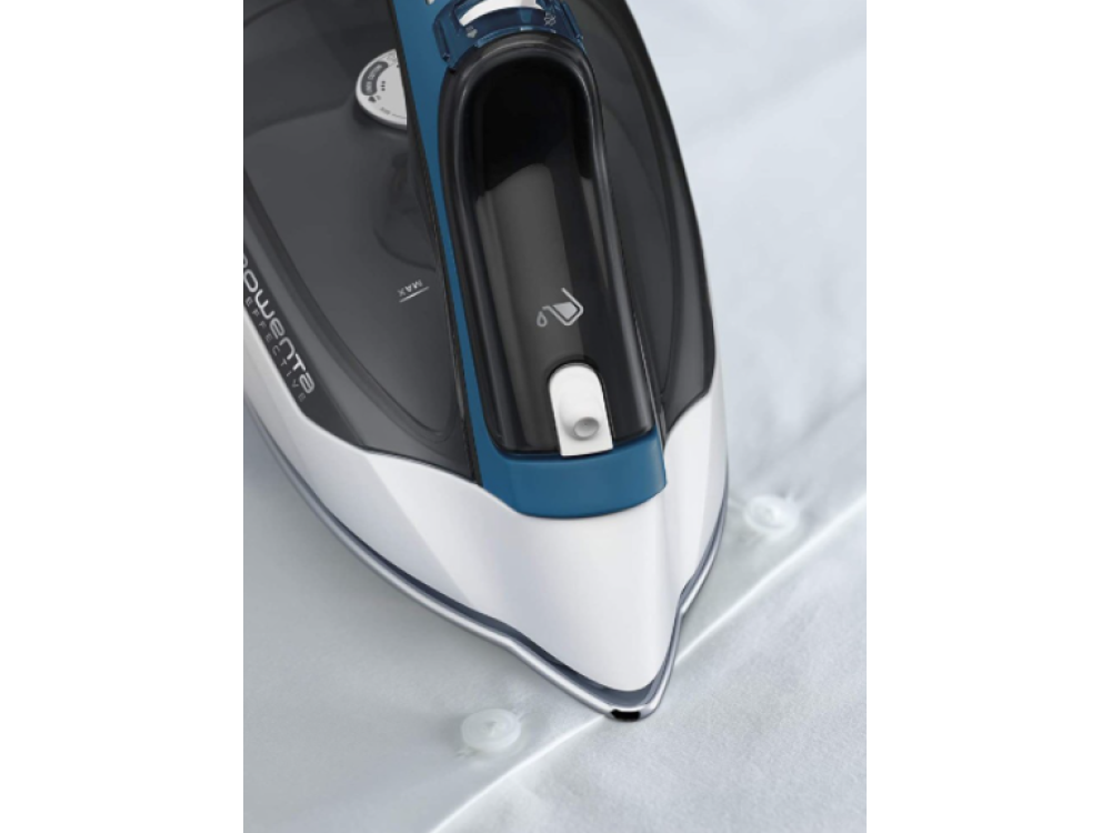 Primer plano de una camisa blanca siendo planchada con una plancha negra y azul. La plancha está sobre la camisa.