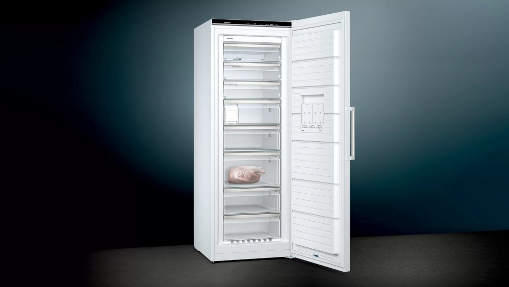 Un réfrigérateur blanc avec la porte ouverte, montrant des étagères et des aliments à l'intérieur.