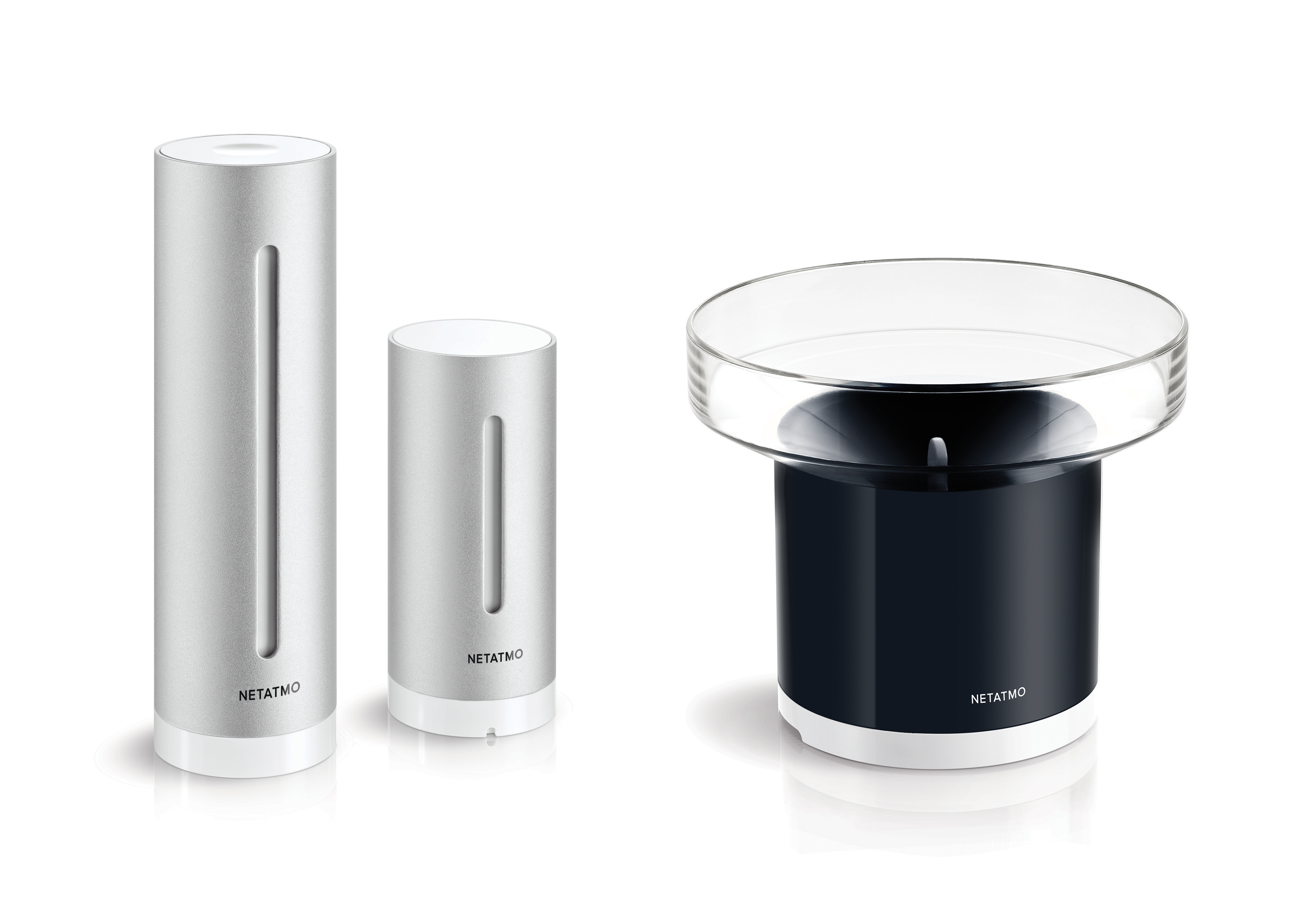 Trois éléments de la station météo Netatmo : deux argentés et un noir.