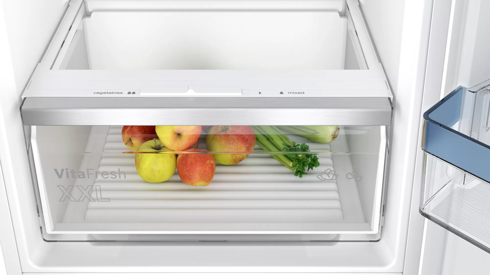 Un tiroir de réfrigérateur rempli de pommes et de céleri.