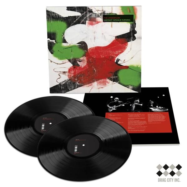 Zwei schwarze Vinylplatten und Albumcover mit abstrakter Kunst davor.