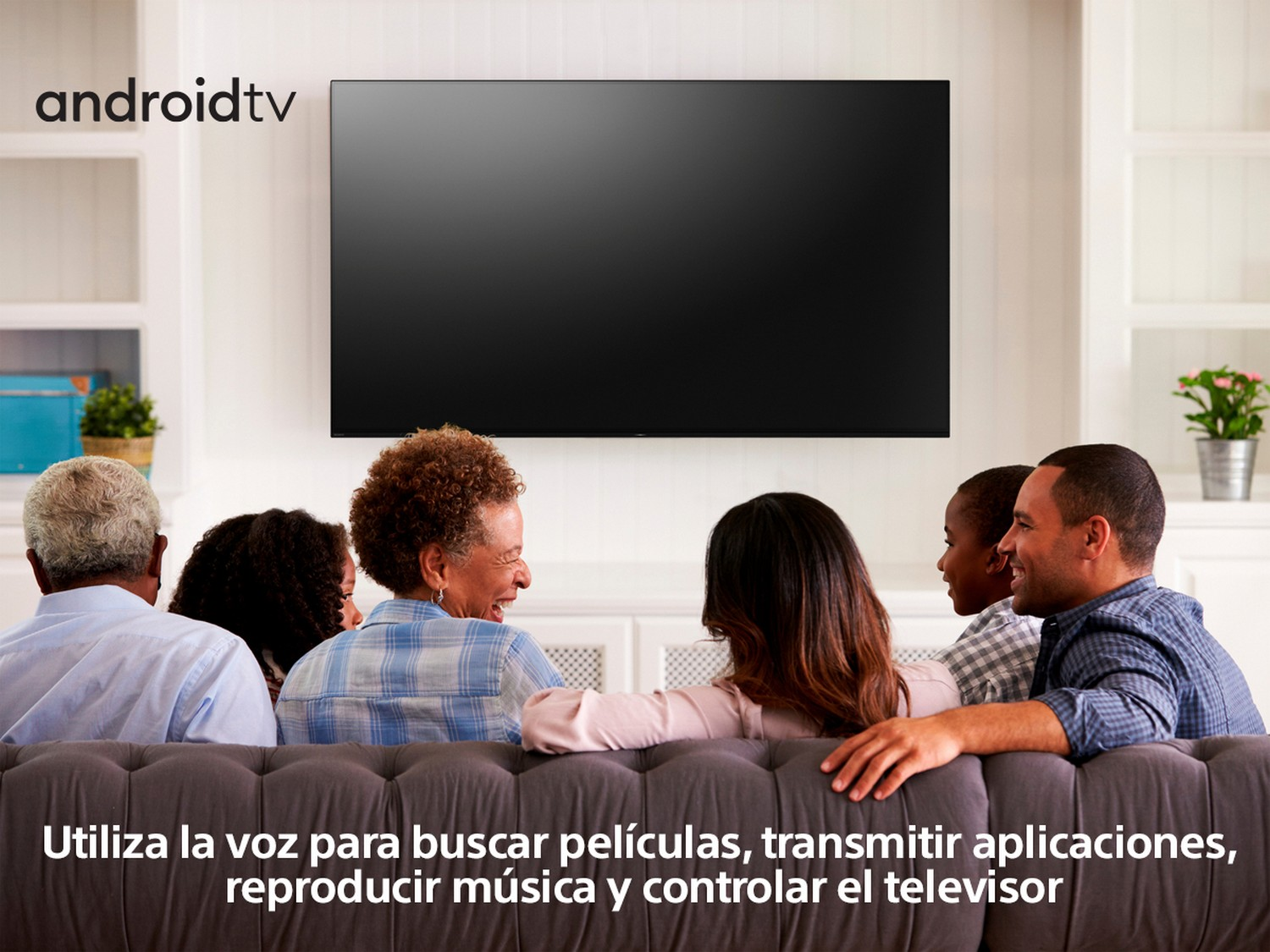 Familia viendo la tele. Texto en español: "Usa la voz para buscar..."