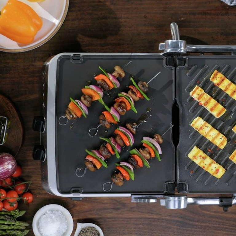 Gegrillte Gemüsespieße und Halloumi auf einem Grill.