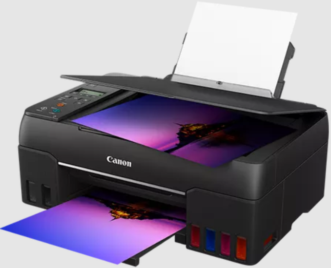 Una stampante Canon nera che stampa immagini colorate, vassoio carta aperto.