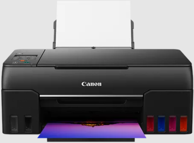 Una stampante Canon nera con serbatoi di inchiostro e una pagina stampata.