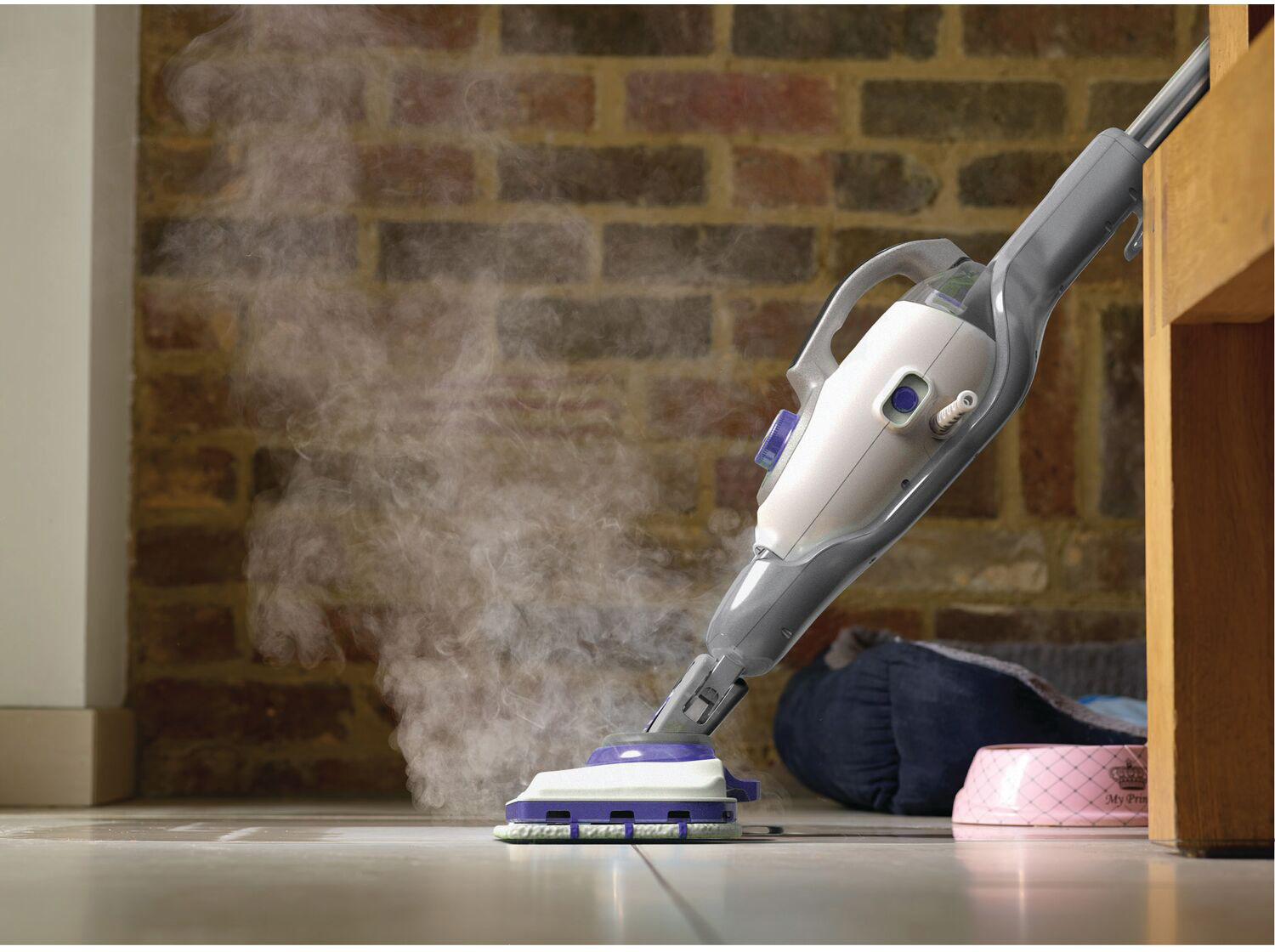 Steam cleaner cleaning a floor. Brick wall background.