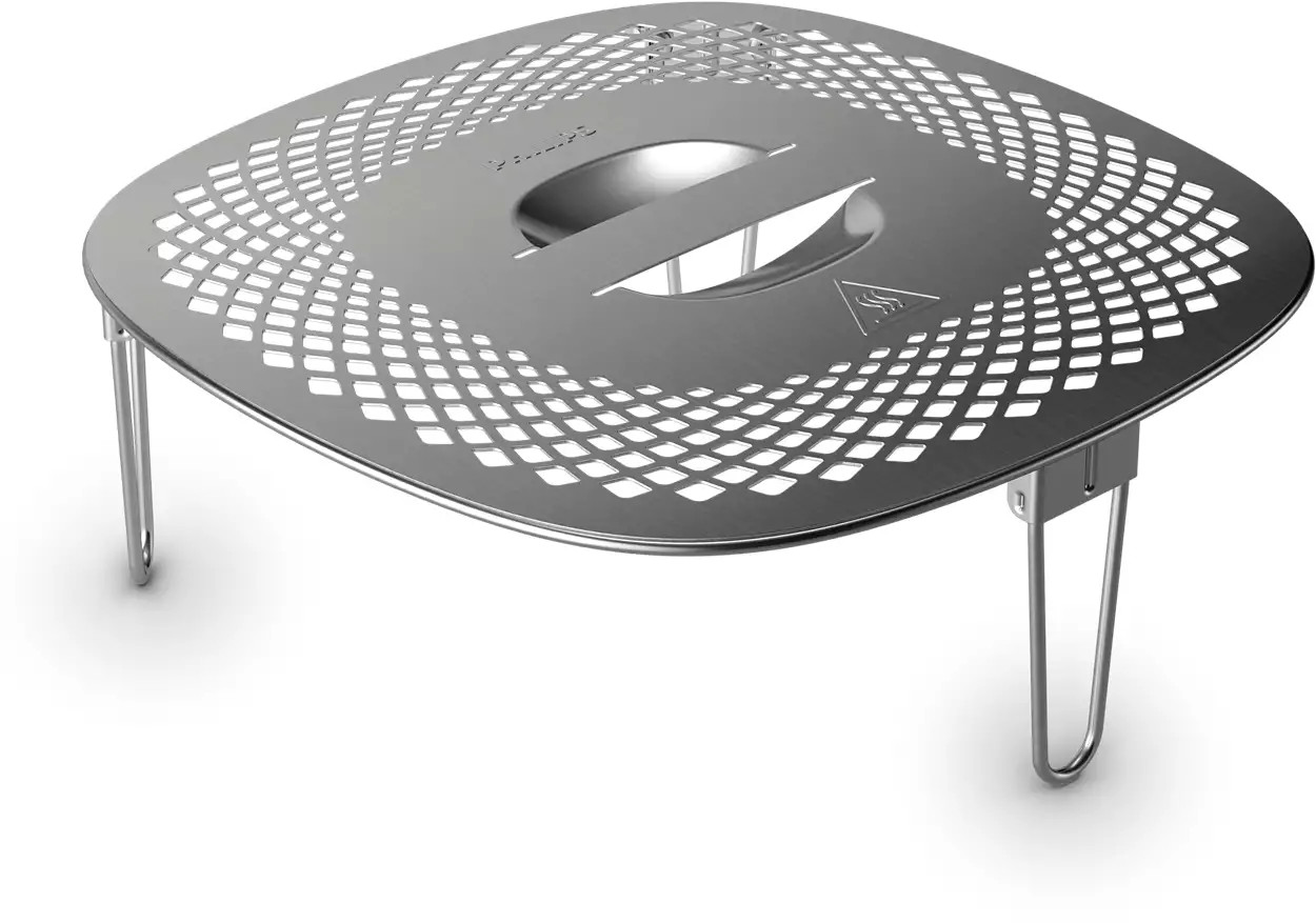 Accessoire de friteuse à air en acier inoxydable avec motif en losanges. Les pieds sont déployés. Fond blanc.