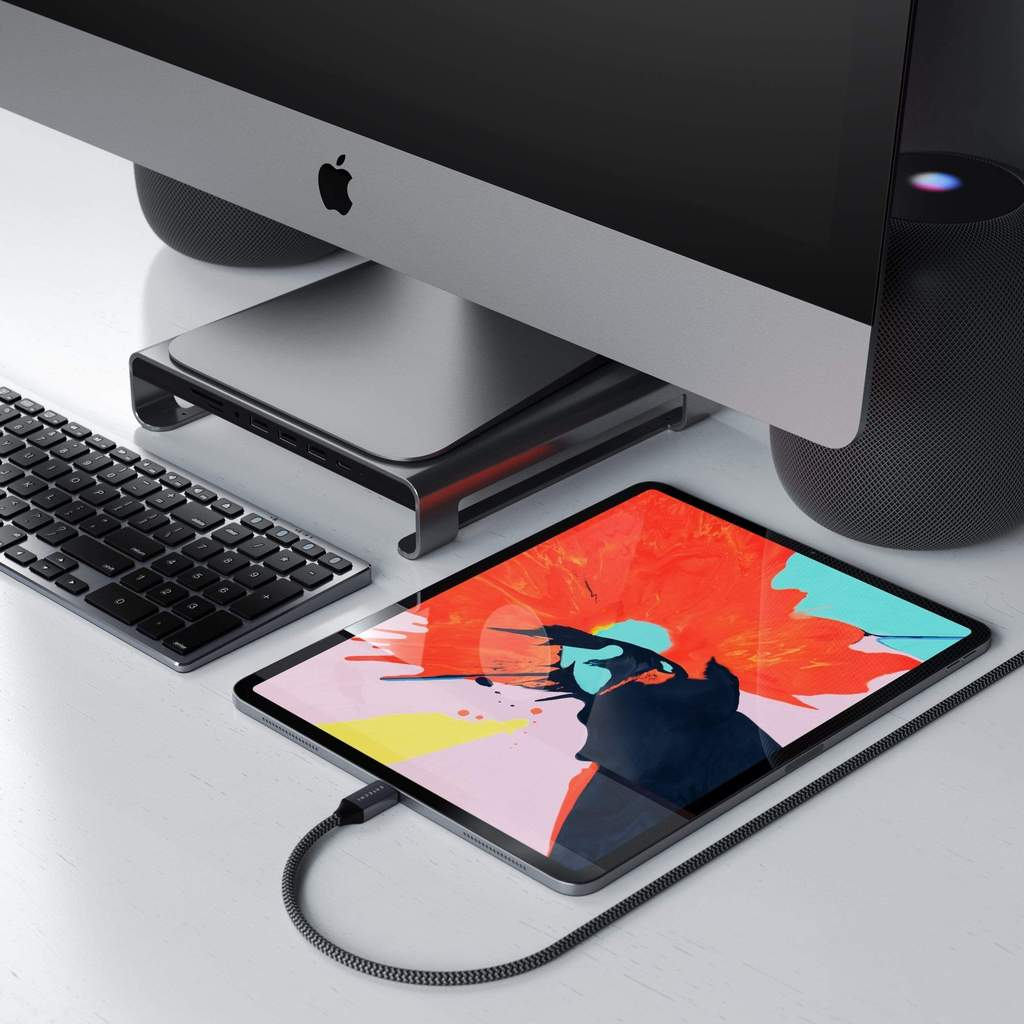 Arbeitsbereich mit Computer, Tablet, Tastatur und Zubehör.