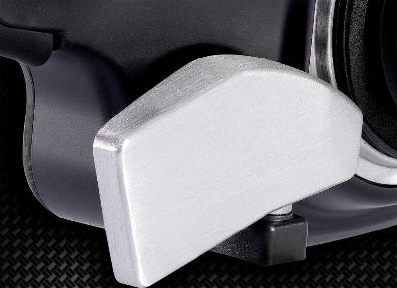 Silberner Griff an schwarzem Gerät. Der Griff ist rechteckig mit gebürsteter Metallstruktur.
