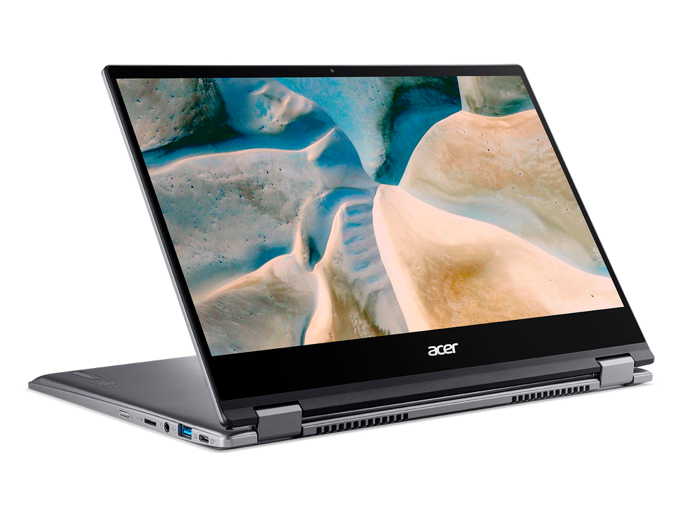 Un portátil Acer plateado, abierto, sobre una superficie negra. La pantalla muestra un desierto.