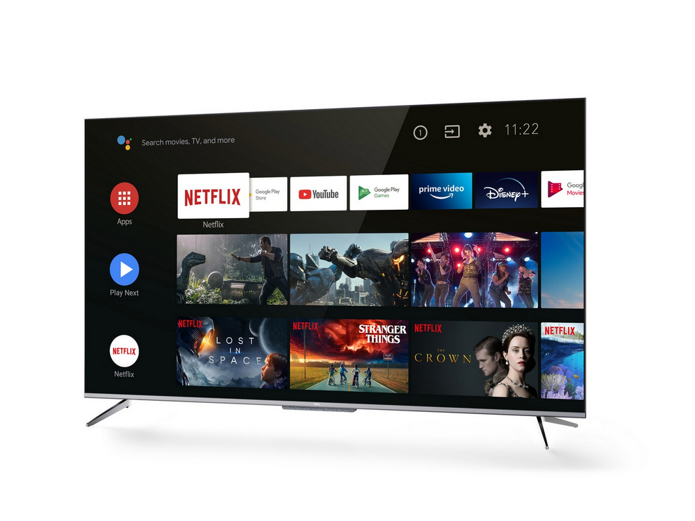 Un televisor inteligente moderno muestra una interfaz de usuario con aplicaciones como Netflix y YouTube. Patas plateadas, fondo blanco.