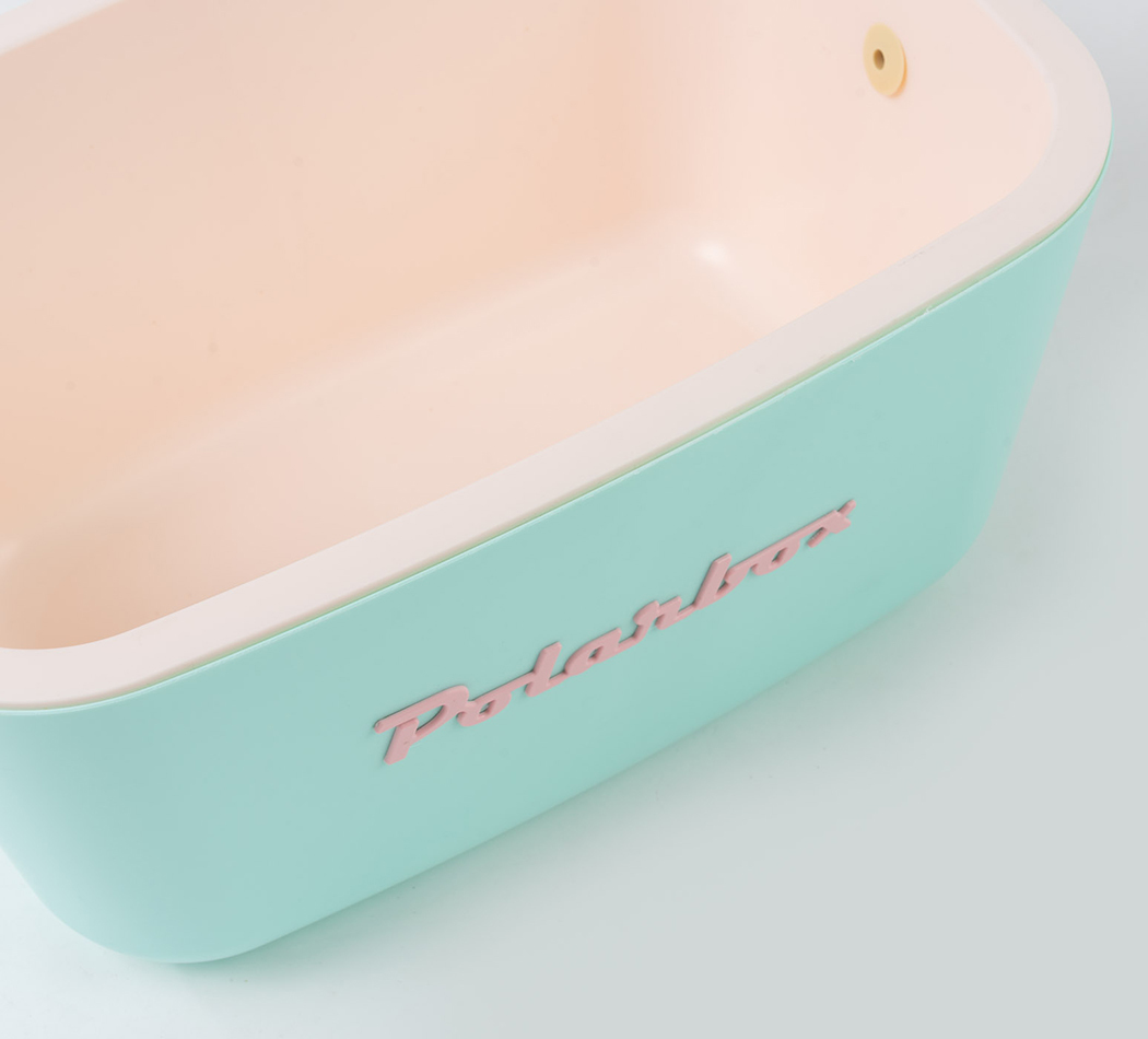 Une baignoire vert menthe et pêche avec une marque de mot rose.