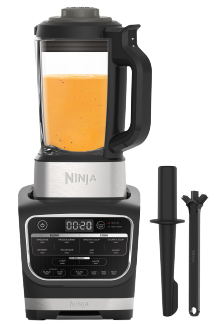 Ein Ninja-Mixer mit orangefarbener Flüssigkeit. Zwei schwarze Werkzeuge liegen daneben.