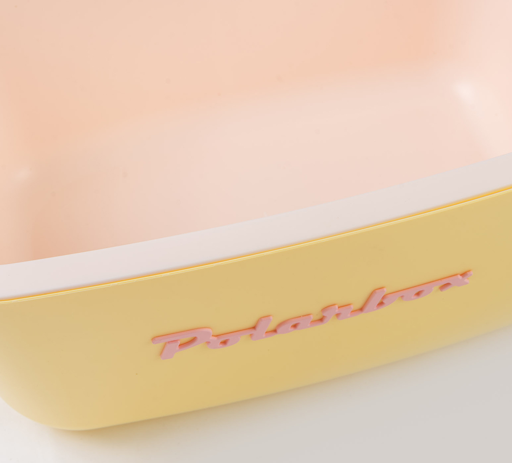Un récipient en plastique jaune avec du texte rose sur le côté, sur fond blanc.
