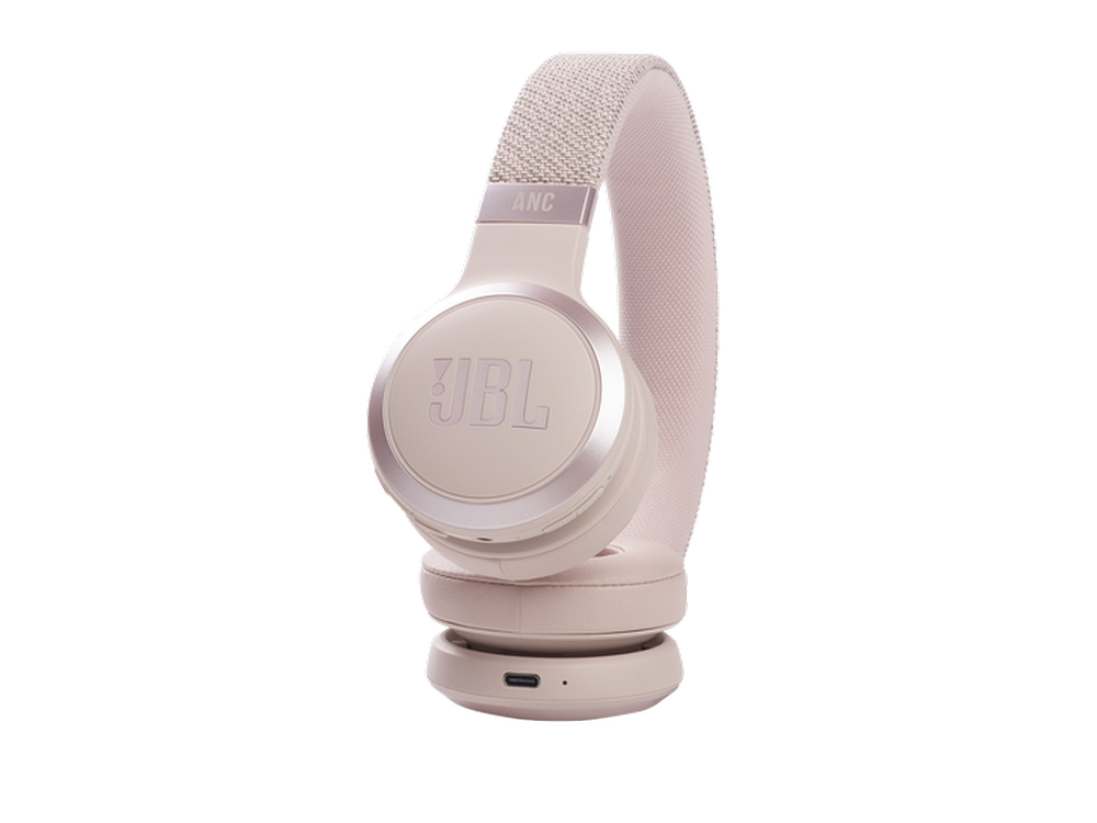 Auriculares JBL beige sobre una superficie blanca. Están en ángulo y muestran los auriculares.