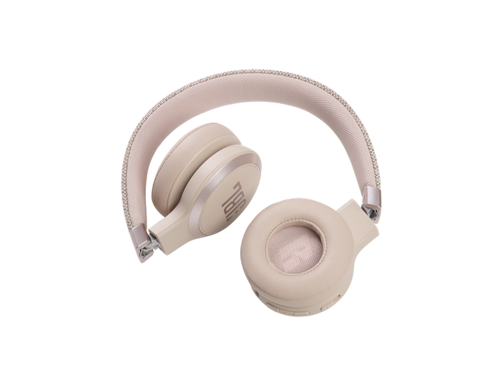 Auriculares JBL beige. Los auriculares están doblados. Fondo blanco.