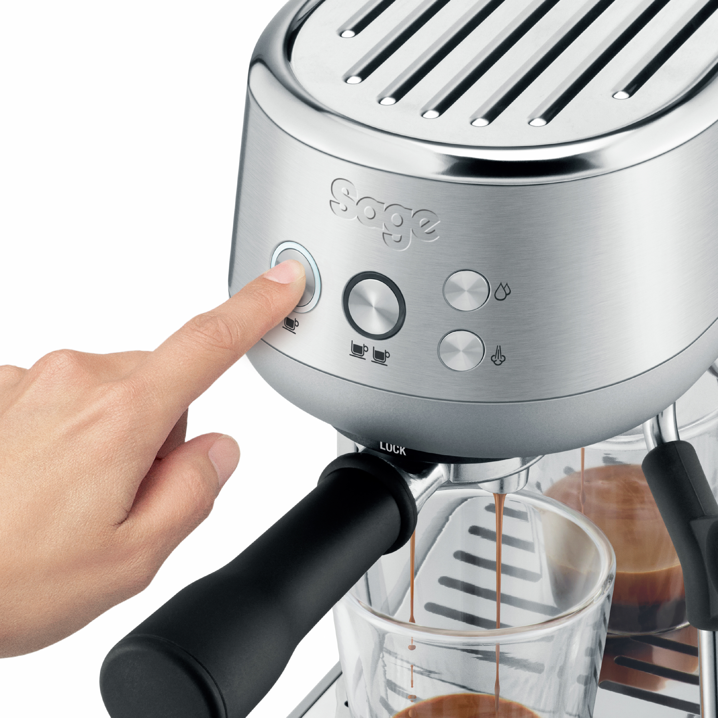 Eine Hand drückt die Einschalttaste einer Espressomaschine aus Edelstahl. Espresso wird gegossen.