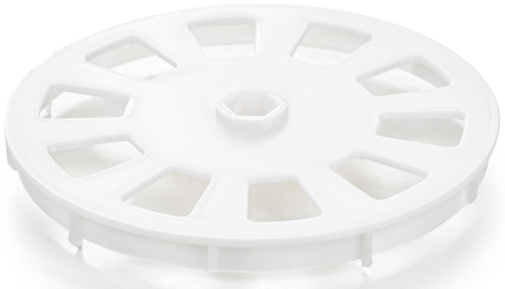 Une pièce circulaire en plastique blanc avec un moyeu central et des ouvertures radiales.