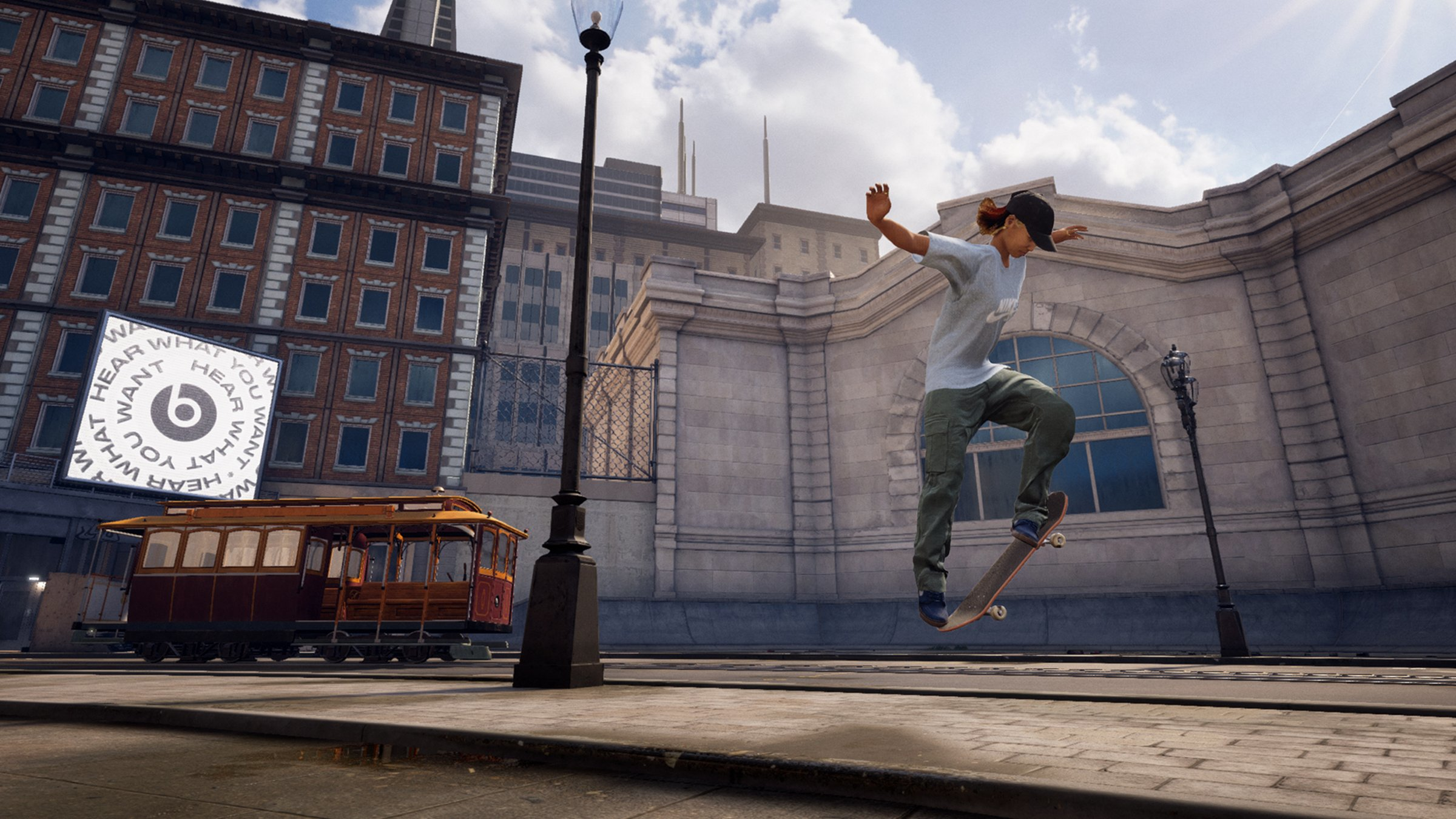 Skateboarder en l'air devant une scène de ville avec une grande publicité Beats.