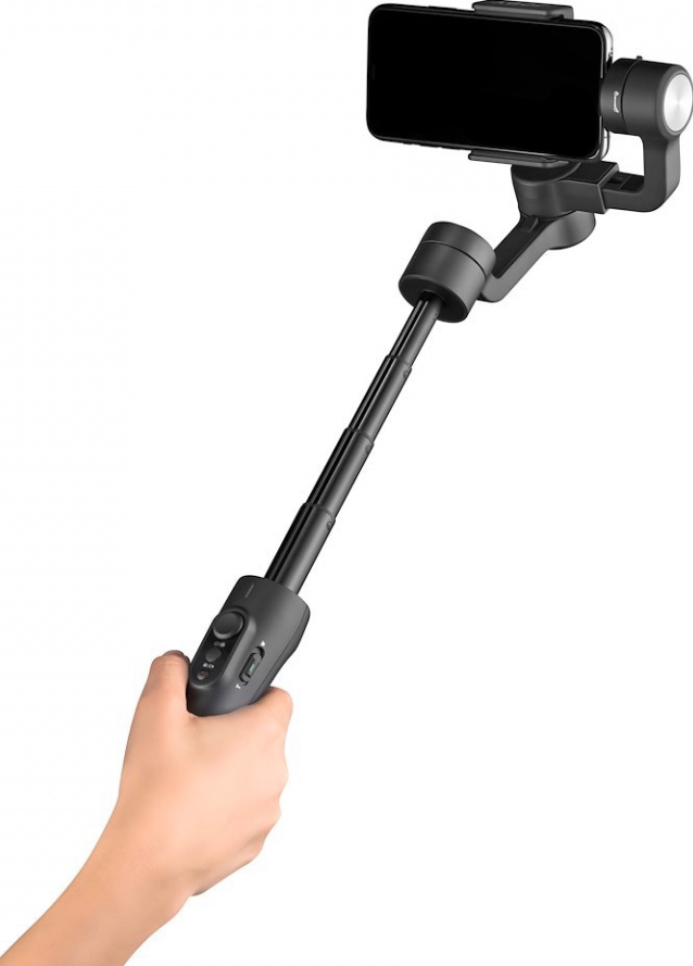 Ein schwarzer Selfie-Stick mit einem angebrachten Telefon. Das Telefon ist schwarz. Eine Hand hält den Stick.