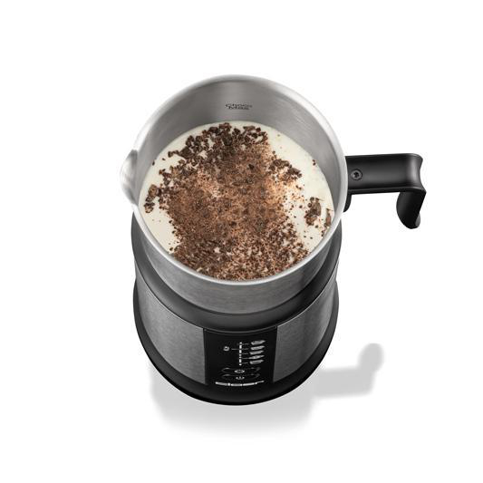 Silberner und schwarzer Milchaufschäumer mit Milch und Schokoladenraspeln.