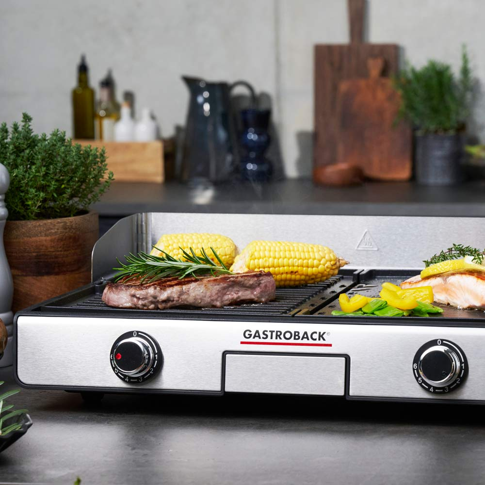 Ein Grill mit Steak, Mais und Fischfilet, mit Rosmarin und Zitrone.