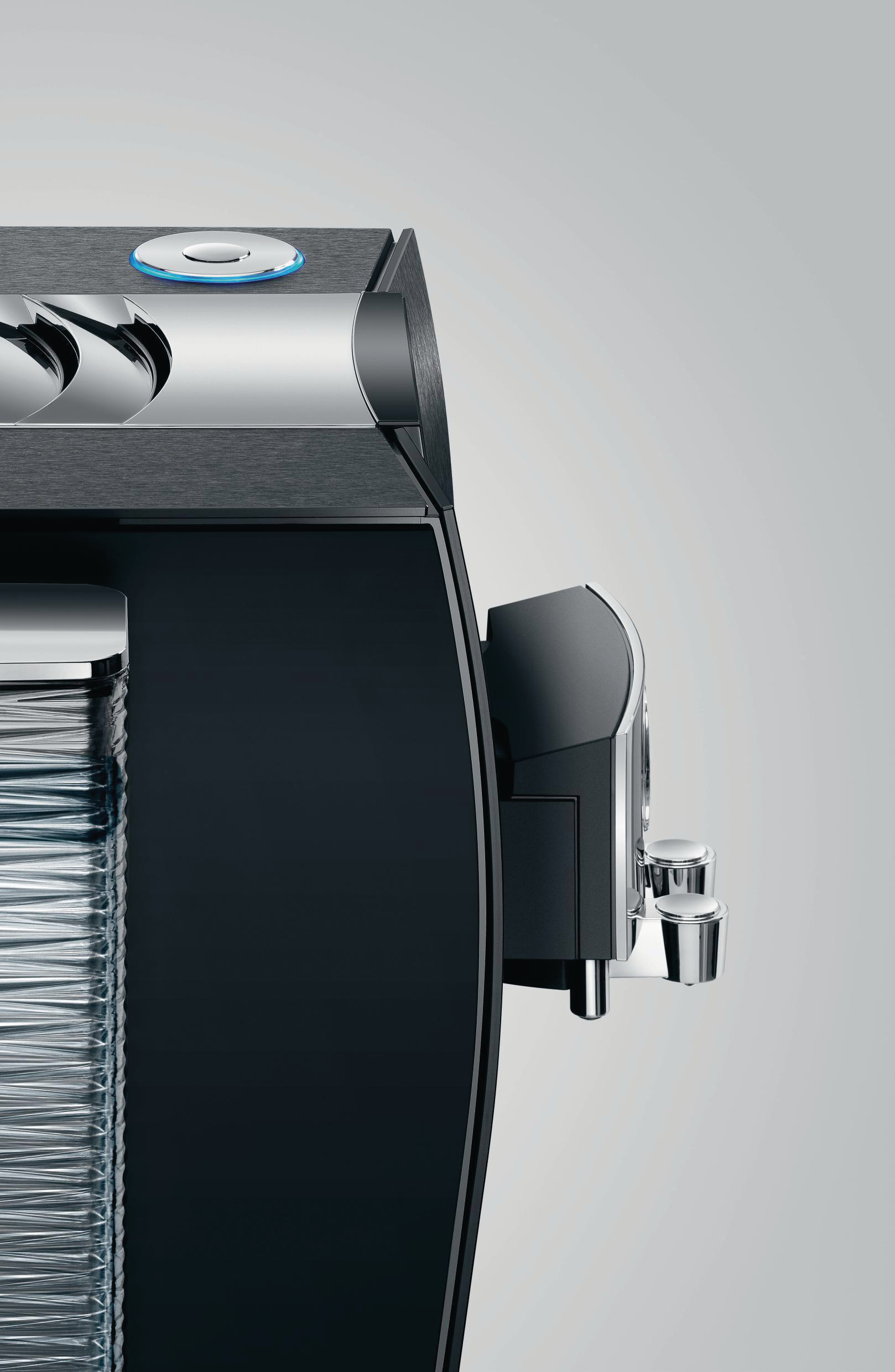 Schwarz-silberne Kaffeemaschine. Seitenansicht. Edelstahl-Düse und Wasserbehälter.