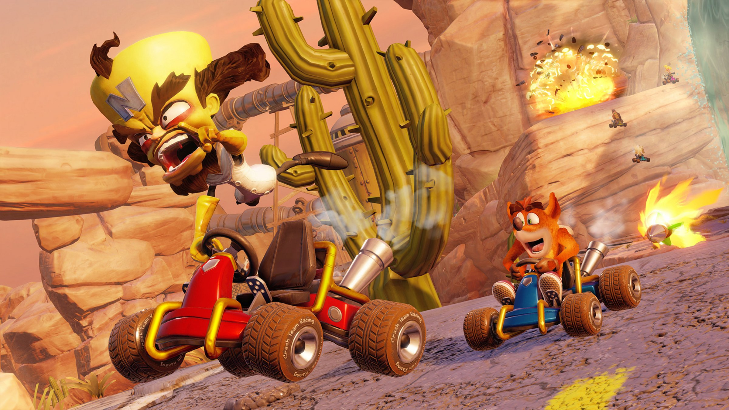Crash Bandicoot et un autre personnage font la course en karts. Un cactus et une explosion en arrière-plan.