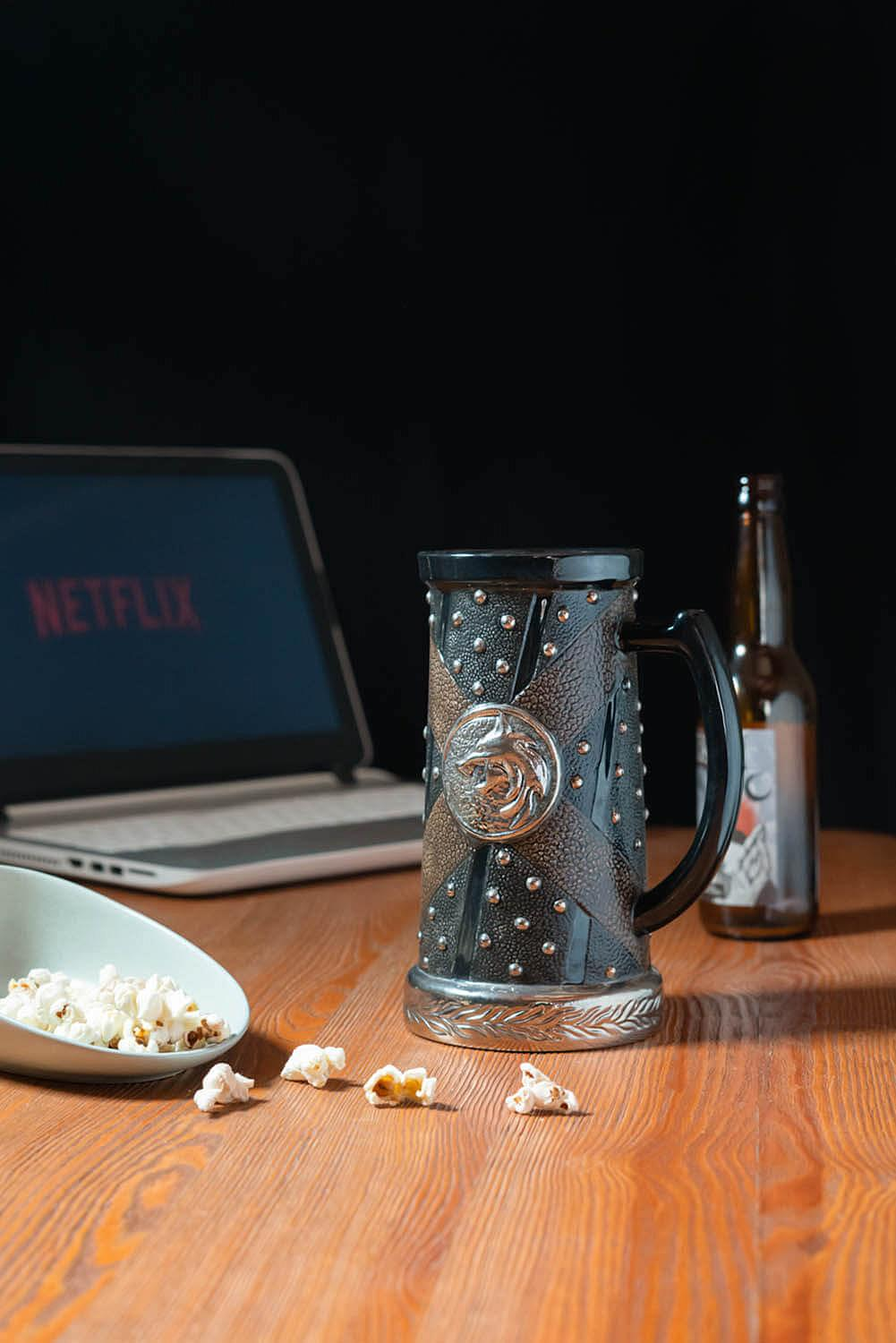 Bierkrug mit Nieten, Popcorn, Bierflasche und Laptop mit Netflix.