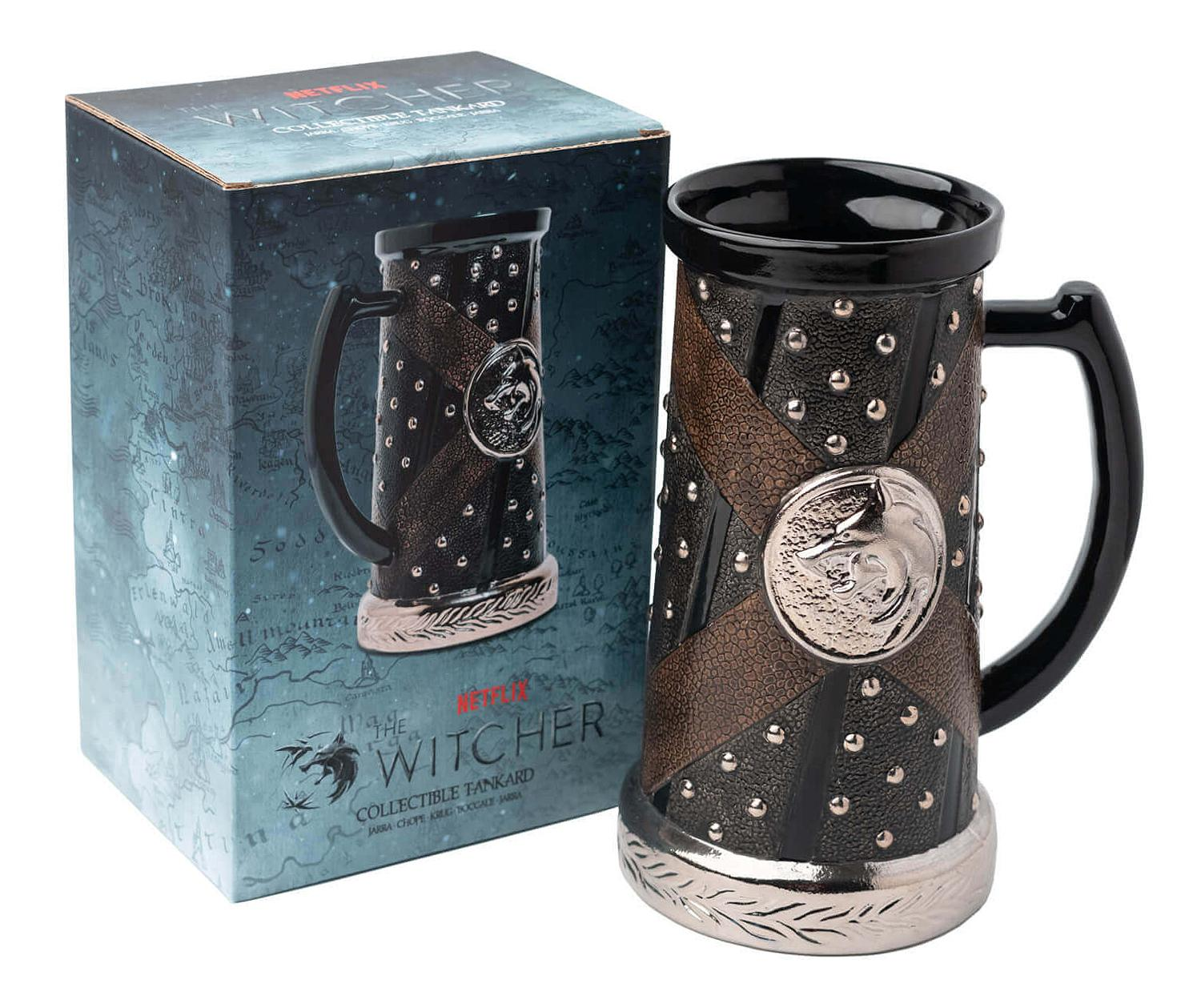 Ein Witcher-Krug mit einer Schachtel daneben. Der Becher ist schwarz mit silbernen Akzenten und einem Griff.