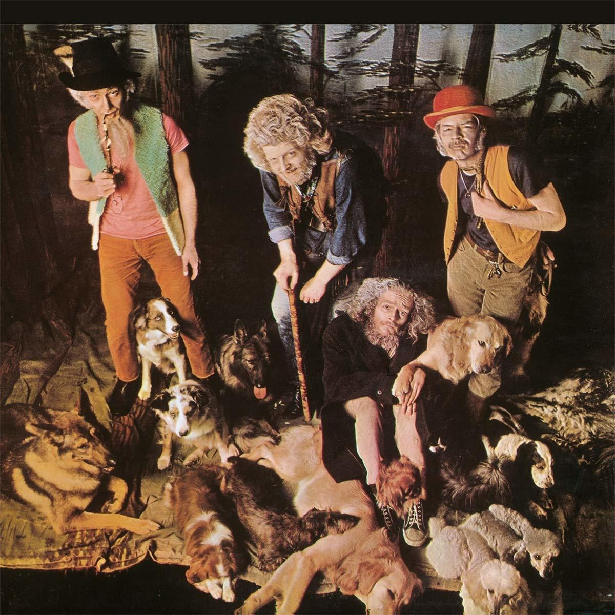 Albumcover mit drei Männern und Hunden in einer Waldszene.