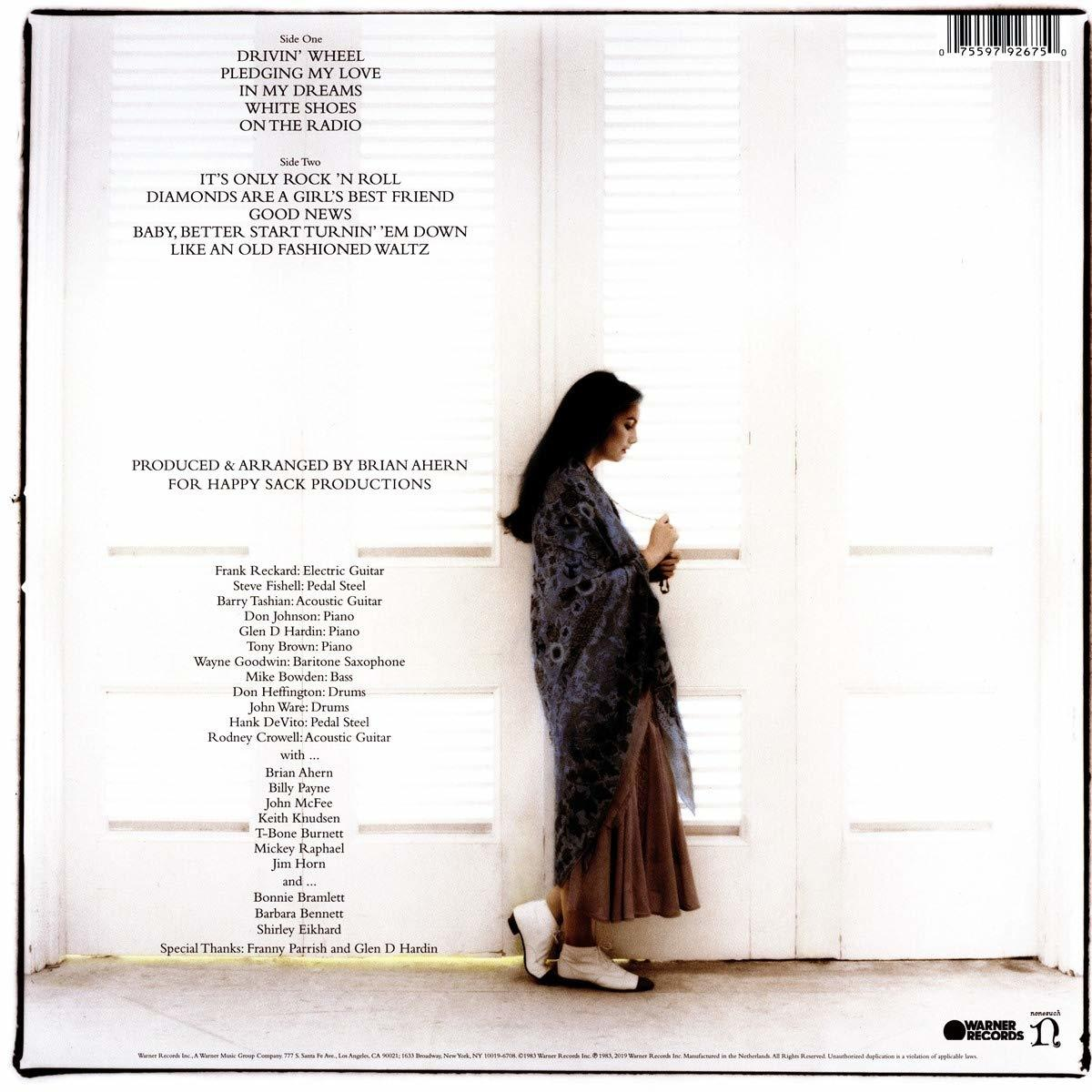 Albumcover mit Frau, die an einer Tür lehnt. Text auf der linken Seite, Warner Records Logo unten.