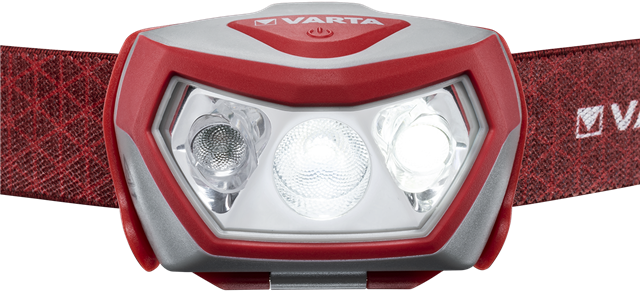 Eine rot-weiße Stirnlampe mit drei hellen Lichtern vor dunklem Hintergrund.