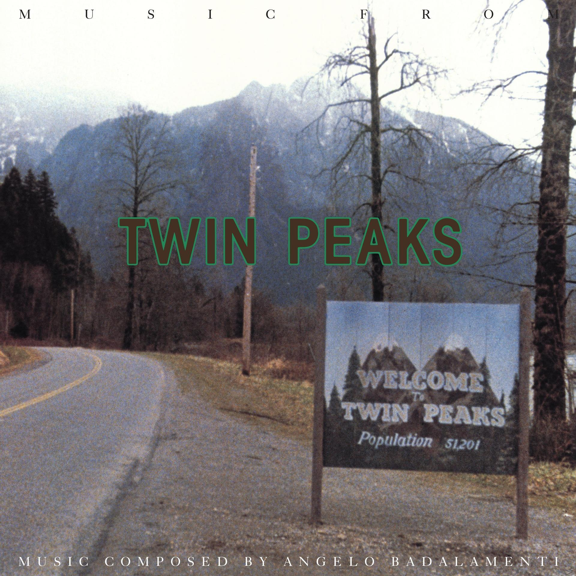 A Twin Peaks tábla egy út mellett áll. A háttérben hegyek, fák és a 'Twin Peaks' felirat látható.