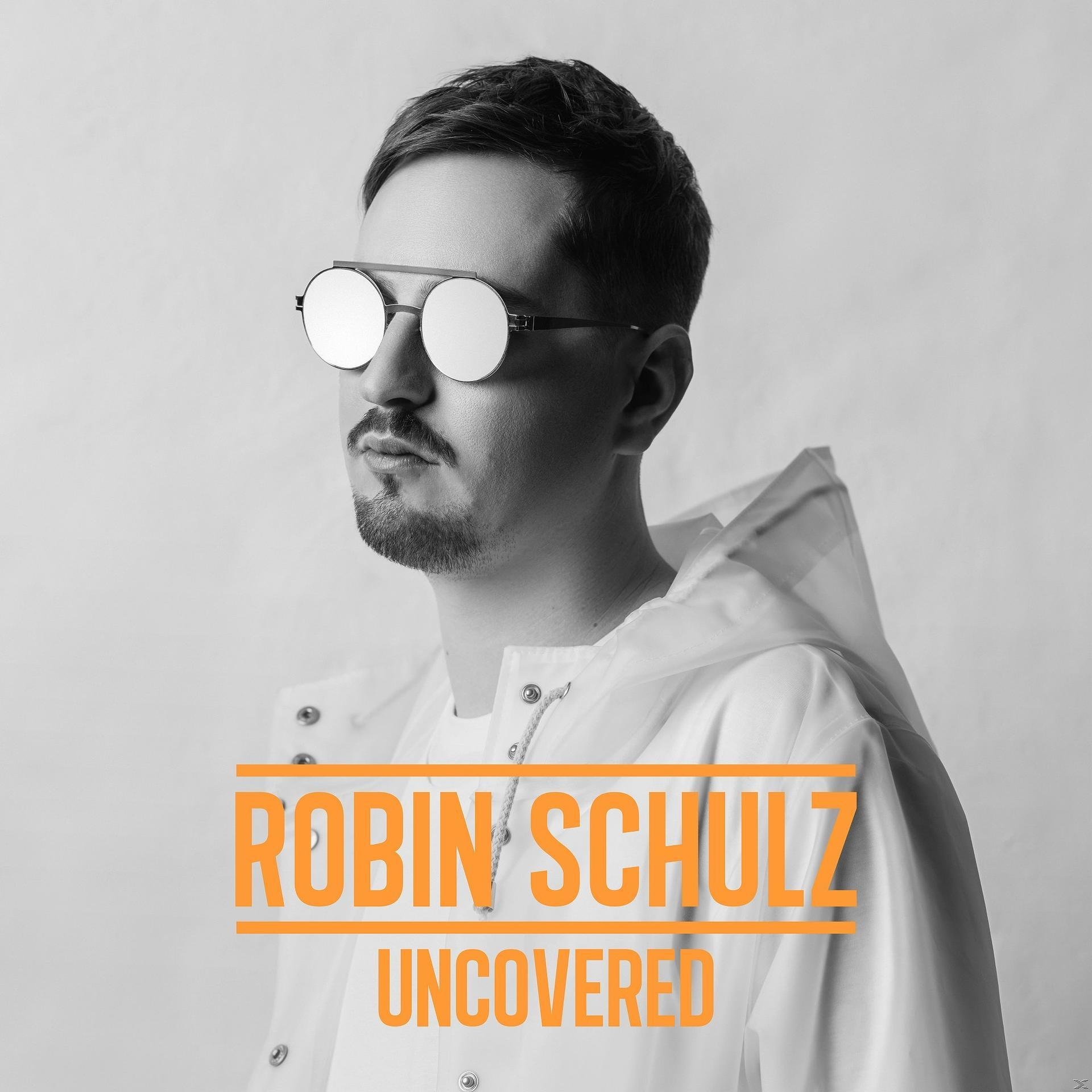 Homme avec des lunettes de soleil, texte orange "ROBIN SCHULZ UNCOVERED". Photo en noir et blanc.