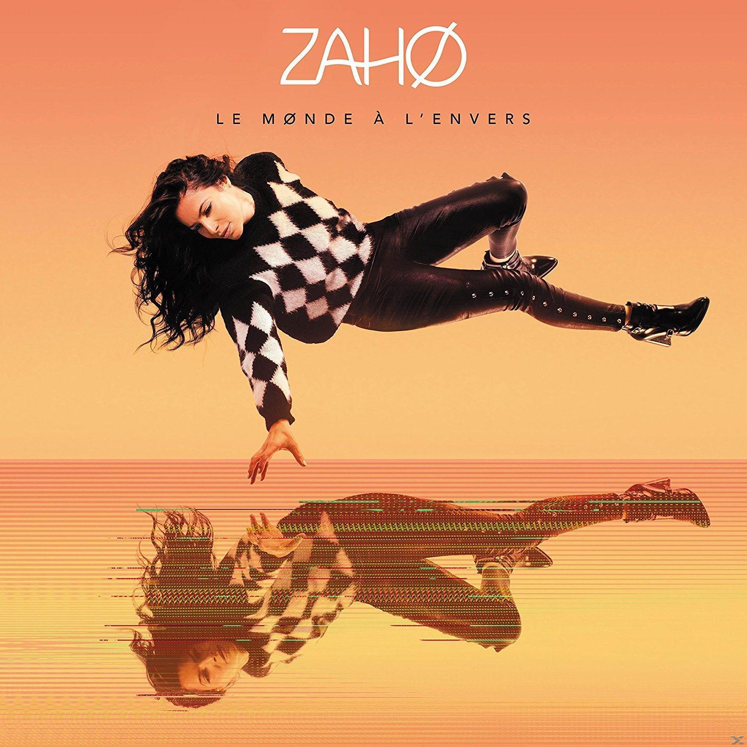 Albumcover mit einer Frau in einem schwarz-weißen Pullover und ihrem Spiegelbild. Oranger Hintergrund.