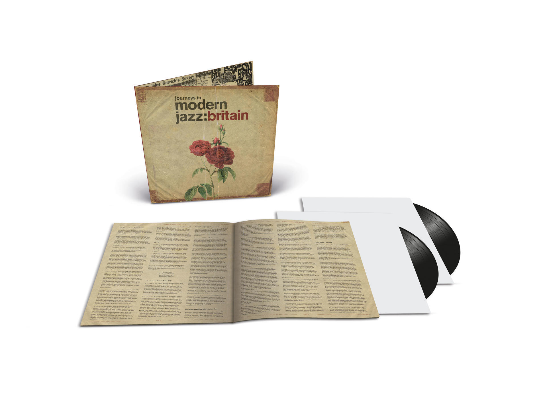 Albumcover mit Schallplatten, in einem Buch, auf einer weißen Oberfläche.