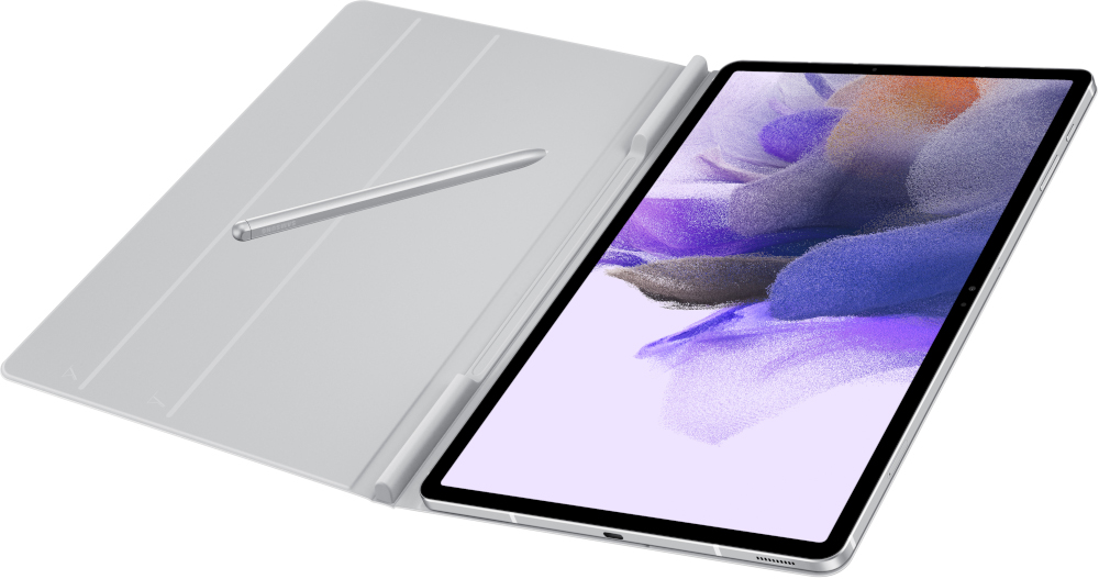 Une tablette argentée avec un stylo posé sur son étui, positionnée en angle, fond blanc.